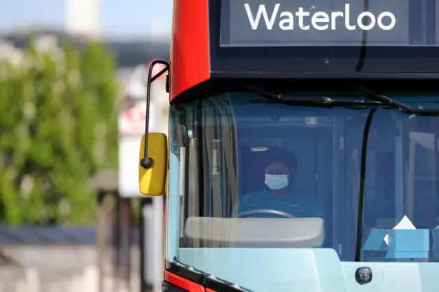 A bus driver wears a face mask