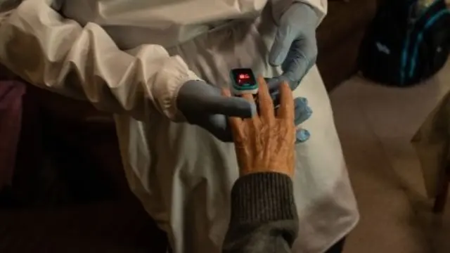 An elderly woman in Spain has her oxygen level checked by an oximeter. File photo