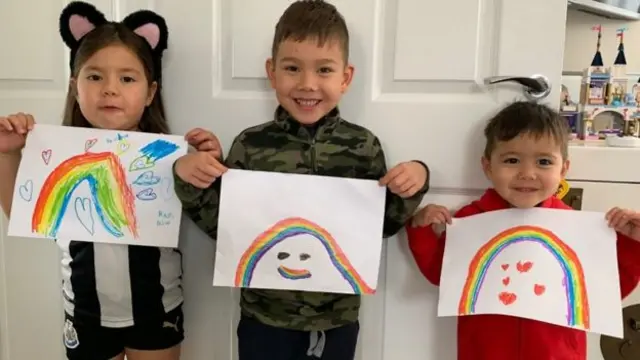 Children hiold their rainbow pictures