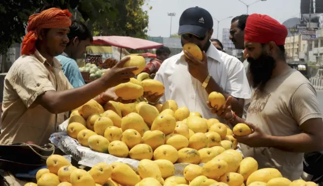 Customers buy mangoes at the roadside stall in Amritsar, India. File photo