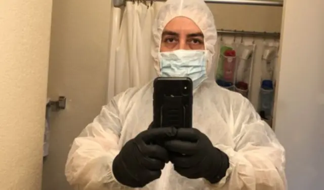 José Zaragoza in his cleaning gear, including a full-body coverall, gloves and a mask