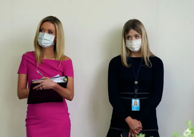 White House Press Secretary Kayleigh McEnany (L) wears a face mask during a press briefing