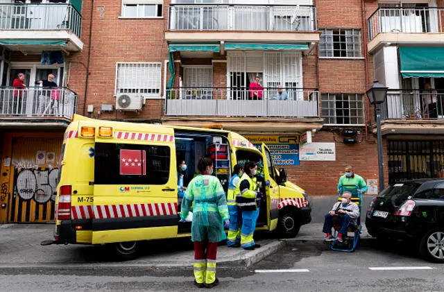 Health workers are seen by neighborhood residents as they perform an emergency service on May 13, 2020 in Madrid, Spain