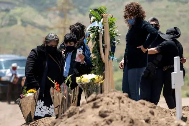 Relatives of a COVID-19 victim attend the burial at the Municipality Cemetery #13 in Tijuana, Baja California State, Mexico, on May 12, 2020,