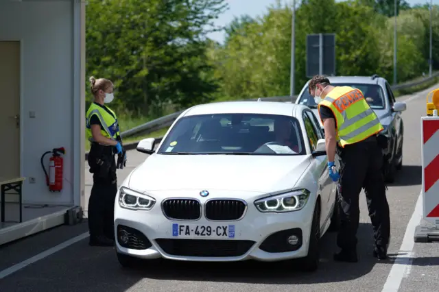 German border police officers stop cars in a checkpoint of the D87 road at the German-French border during the coronavirus crisis on May 8, 2020 near Rastatt, Germany.