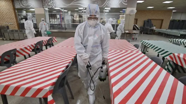 Worker disinfecting a school canteen