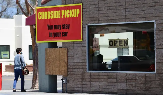 An employee inside a restaurant waits for customers arriving for pickup in Alhambra, California on May 7, 2020.