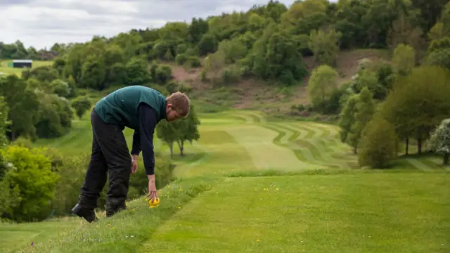 A green keeper puts down a tee marker at Llanymynech Golf Club