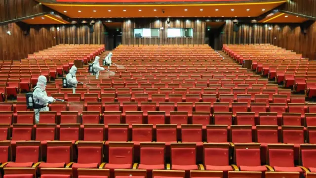 Workers disinfecting a theatre