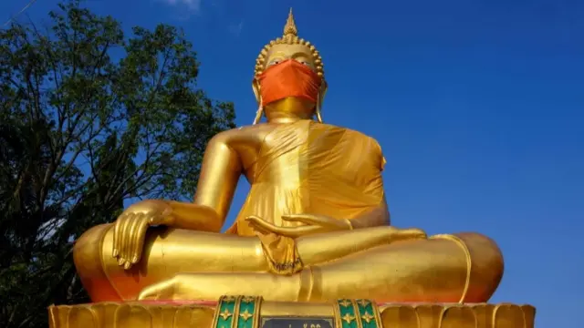 Thai statue wearing a face mask