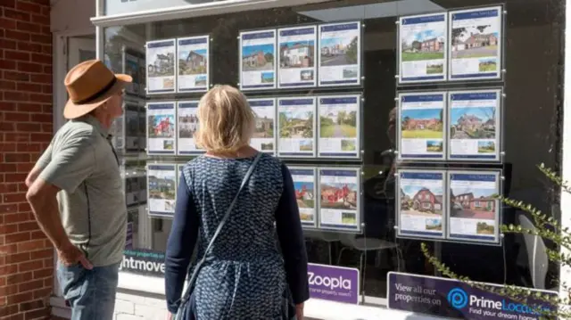 Couple looking in an estate agent's window