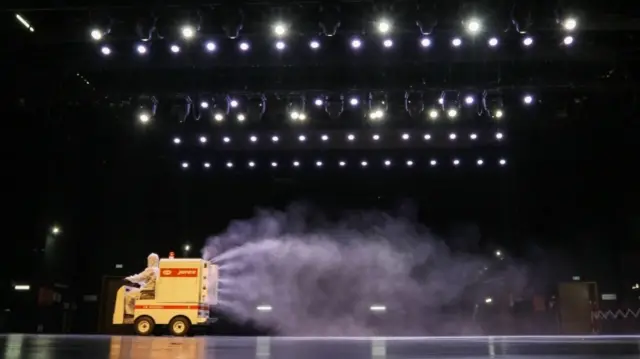 Workers disinfecting a theatre stage