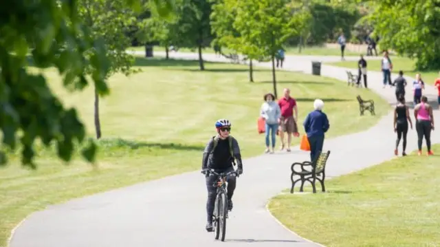 A woman cycles through a park