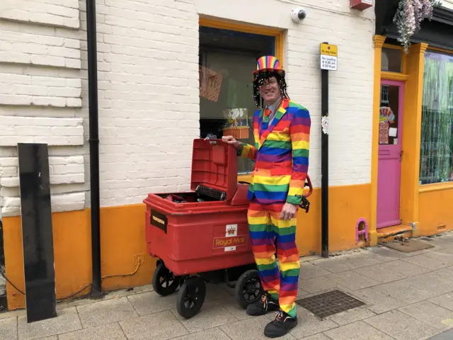 Postman in rainbow outfit