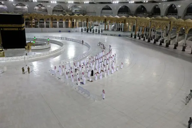 Worshippers perform Isha prayer while keeping distance between them next to the Kaaba in Mecca's Grand Mosque, Islam's holiest site on April 27, 2020.