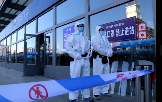 Policemen cordoning off a railway station in Jilin city