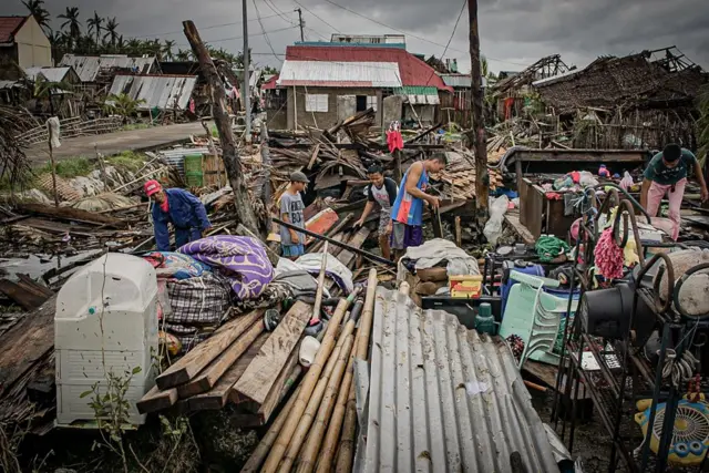 Residents try to salvage belongings amongst their houses destroyed at the height of Typhoon Vongfong