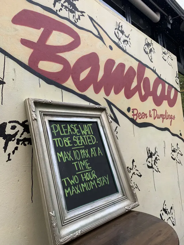 A sign outside a bar in Sydney saying 10 people at a time, two hour max stay