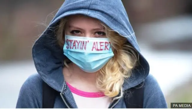Woman wearing a face mask saying "Stayin' alert"