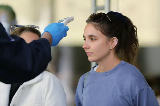 Temperature checks are carried out on people entering the Apple store in Perth's CBD on May 18, 2020