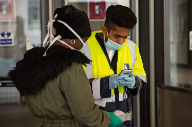 Woman and station staff member at Birmingham New Street station