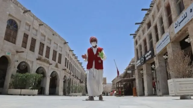 A staff member wearing a protective mask walks by at the tourist Souq Waqif bazar in the Qatari capital Doha