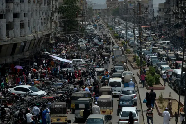 Commuters make their way along a busy street in a market area after the government eased the nationwide lockdown imposed as a preventive measure against the COVID-19 coronavirus, in Karachi on May 14, 2020.