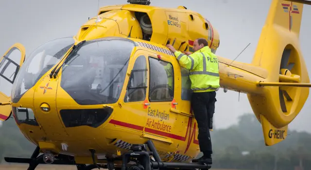 Prince William with a East Anglian Air Ambulance helicopter