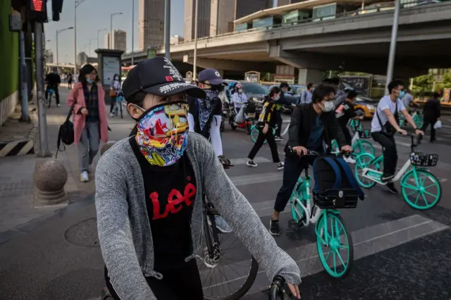 People wearing face masks commute during morning rush hour in Beijing on May 19, 2020