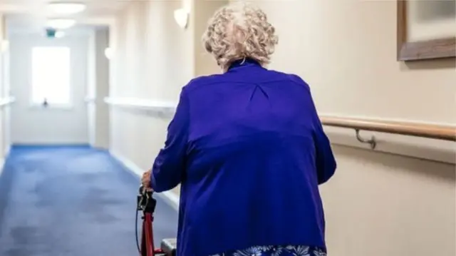 Elderly person walking in corridor