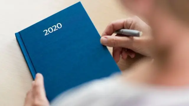 File photo of a woman holding a 2020 diary