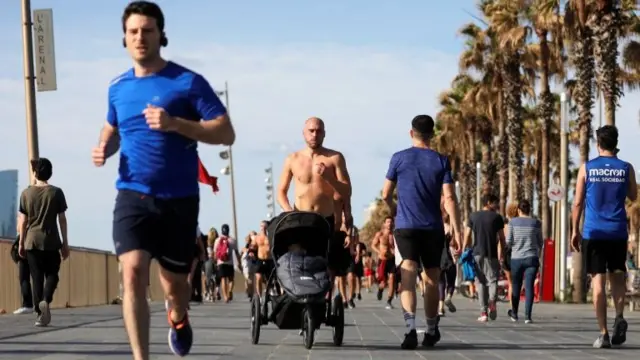 People run at the Barceloneta beach for the first time since the lockdown was announced in Barcelona, Spain, May 2, 2020