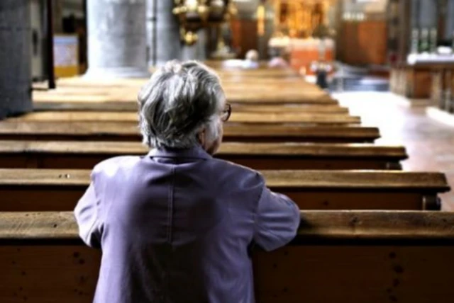 Person kneeling in church