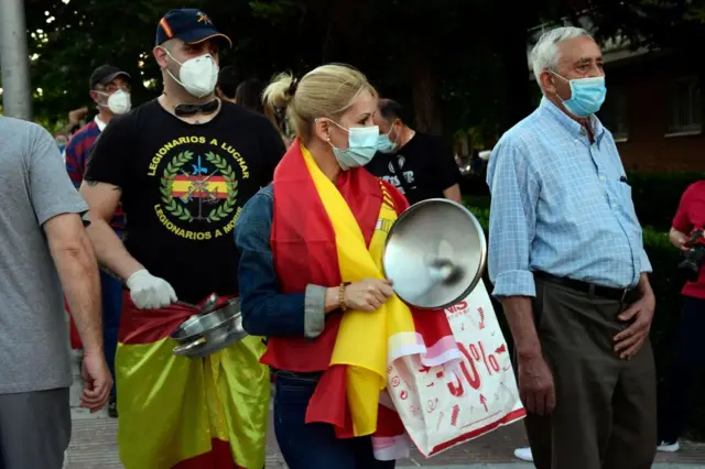 Demonstrators bang pans as they take part in a demonstration against the government's handling of the coronavirus crisis, on 20 May 2020, in Alcorcon, near Madrid