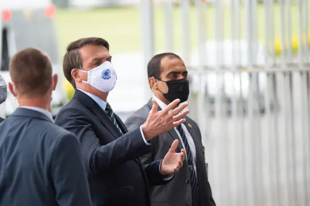 President of Brazil Jair Bolsonaro talks to supporters of his government who waited for him outside the Palácio do Alvorada  pandemic on 20 May, 2020 in Brasilia