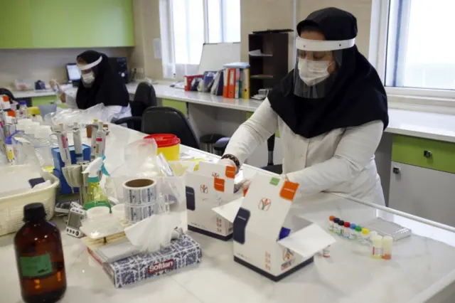 Iranian medical staff work on the production of Covid-19 test kits