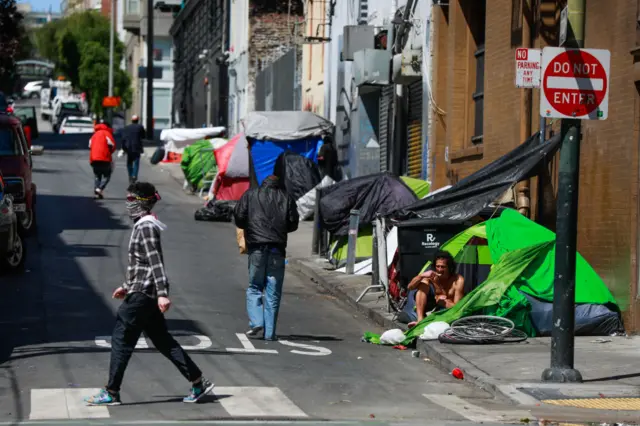 Homeless people gather on Willow Street in the Tenderloin on Wednesday, May 6, 2020 in San Francisco.