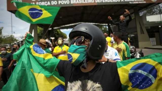 Woman wearing face mask waving Brazilian flag