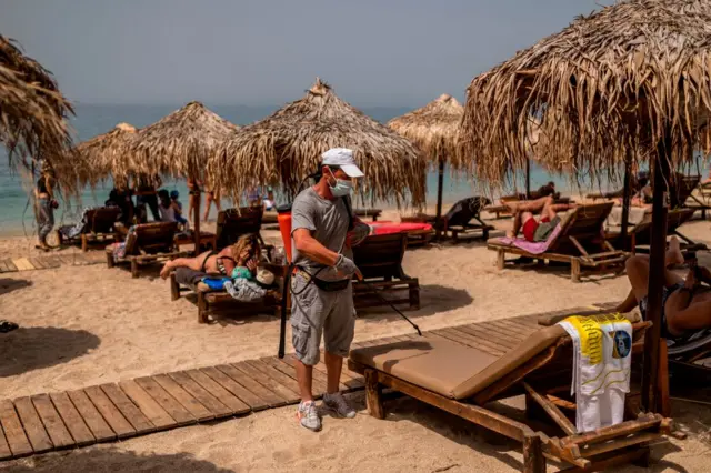 A worker disinfects beaches in Greece