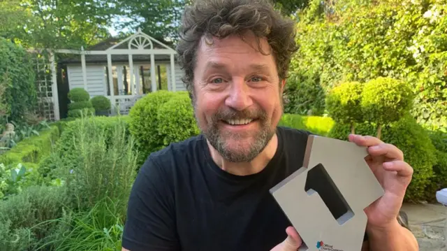 Michael Ball holding a number one sign