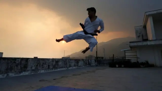 Karate fighter jumping on a rooftop