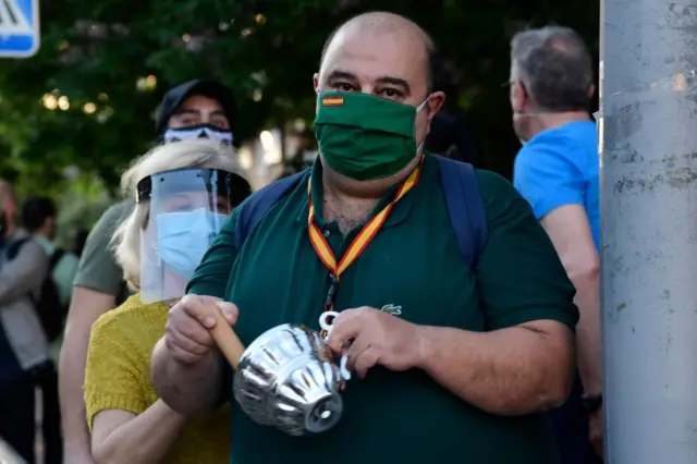 A demonstrator bangs a pot as he takes part in a demonstration against the government's handling of the coronavirus crisis, on 20 May 2020, in Alcorcon, near Madrid