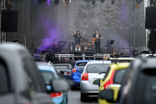 Australian musician Cass Hopetoun (C-L) performs during a drive-in concert at the Robyn Webster Sports Centre in Sydney, Australia, 21 May 2020.