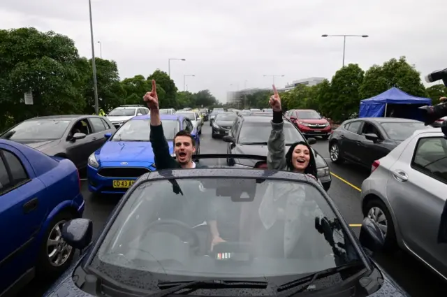 A couple reacts during Australian singer Casey Donovan's live performance during a drive-in concert at the Robyn Webster Sports Centre in Sydney, Australia, on 21 May 2020