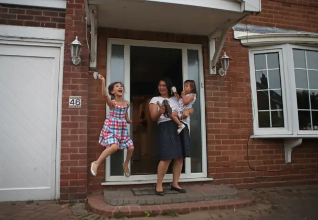 People outside their houses in Woodesford, Leeds, clap to salute local heroes