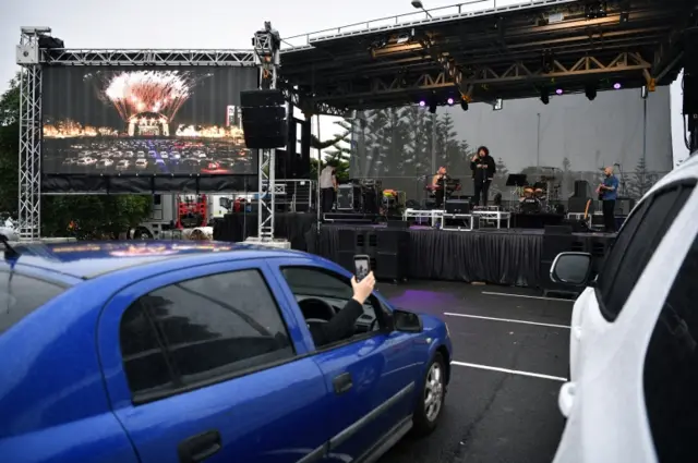 Australian singer Casey Donovan (C-R, back) performs live during a drive-in concert at the Robyn Webster Sports Centre in Sydney, Australia, 21 May 2020