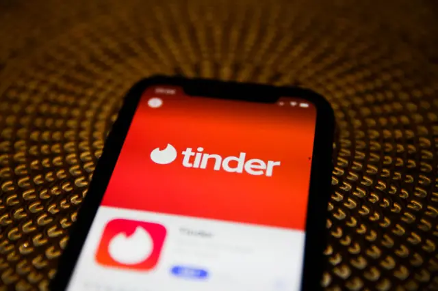 Tinder logo is seen displayed on phone screen