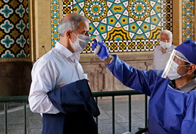 Shia Muslim has his temperature checked before entering the Shah Abdol Azim shrine in Tehran on 25 May 2020