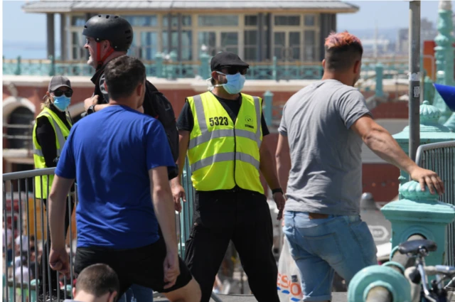 A steward at an entrance to the beach in Brighton