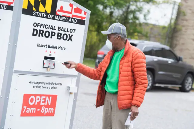 A voter casts a ballot at a drop box in the election to fill the remainder of the late Rep. Elijah Cummings term near Edmondson High School in Baltimore, Maryland on 28 April, 2020.